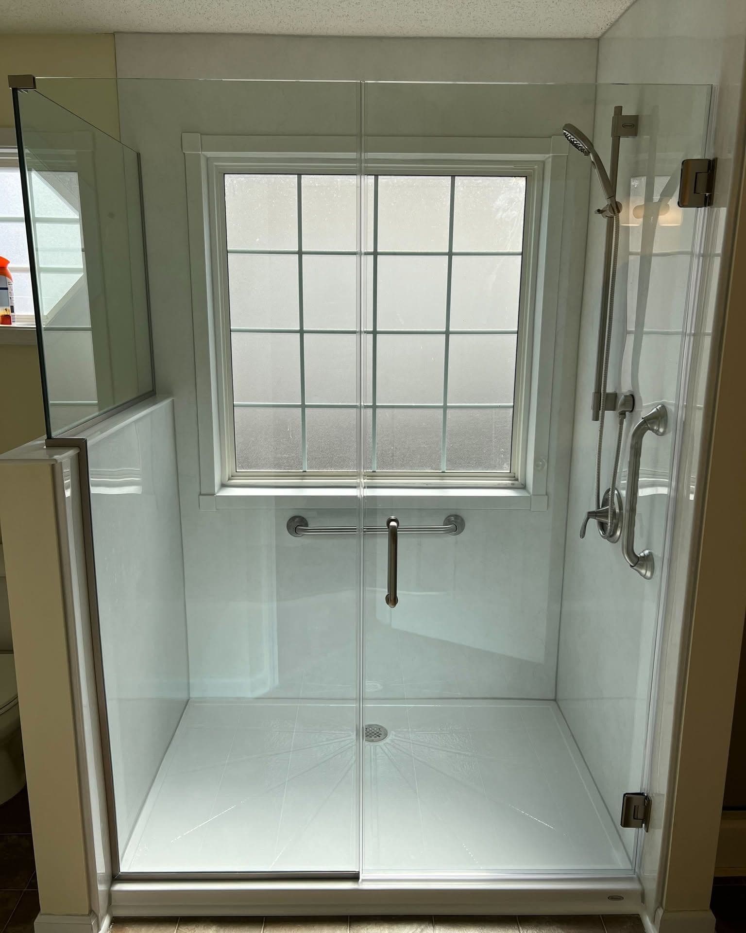 Frameless glass shower enclosure with dual swing doors, chrome fixtures, and a window above the shower head
